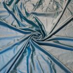 Blue fabric with swirling folds and creases.