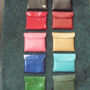 Ten colorful fabric swatches arranged in two vertical columns on a dark surface.