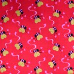 Red fabric with bees and hearts pattern.