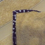 Yellow towel with dark patterned border.