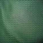 Green textured fabric with woven pattern.