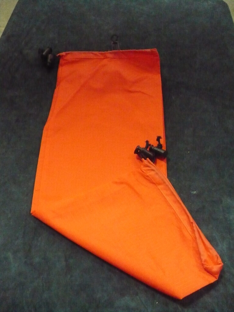 An orange fabric sleeve with a black bat decoration