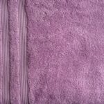 Purple textured towel with striped edge.