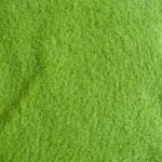 Green textured towel fabric close-up.