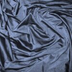 Dark blue satin fabric with folds.