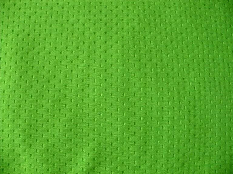 Green textured fabric with small perforations