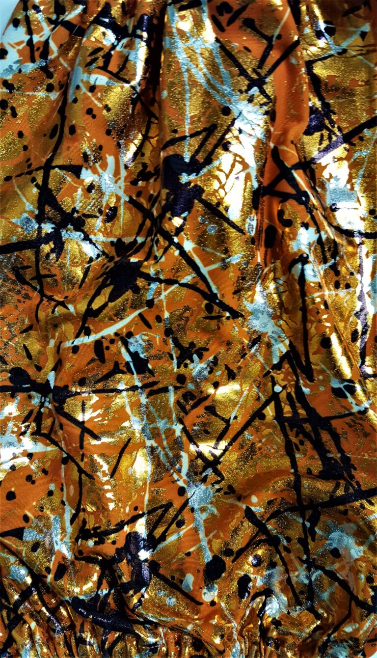 Abstract orange fabric with black and white splatters