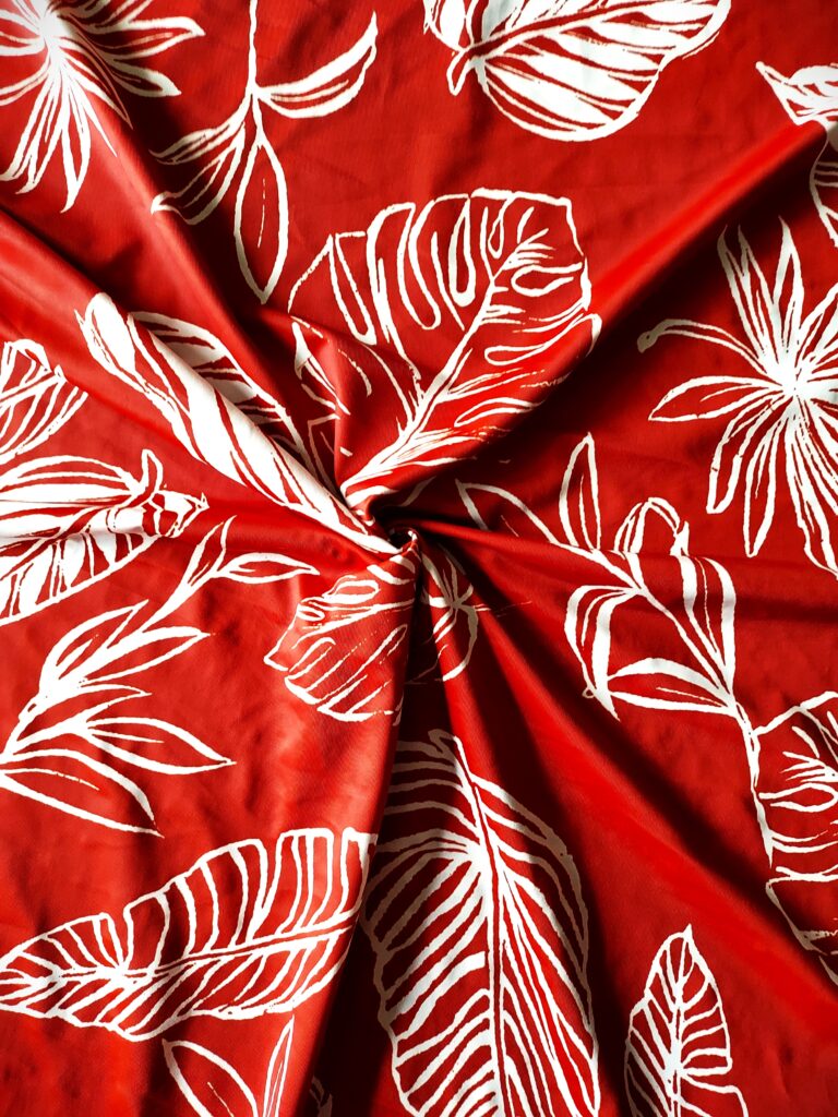 Red fabric with white tropical leaf patterns