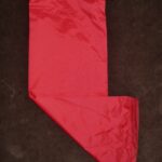 A red satin Christmas stocking on a dark surface.