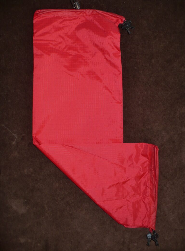 A red satin Christmas stocking on a dark surface