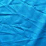 Wrinkled blue fabric texture, close-up view.